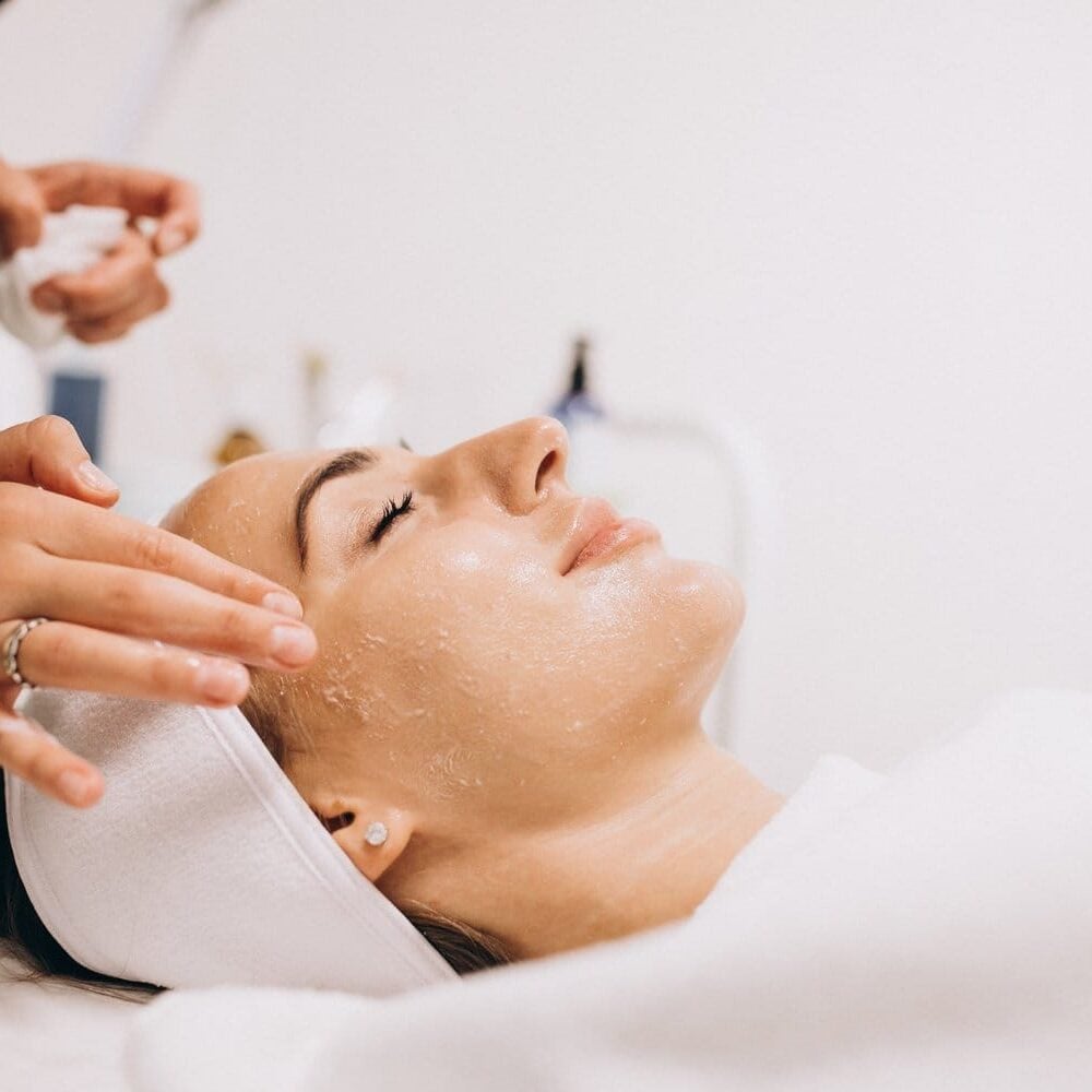 Cosmetologist cleaning face of a woman in a beauty salon facial lasalle revery medical aesthetics