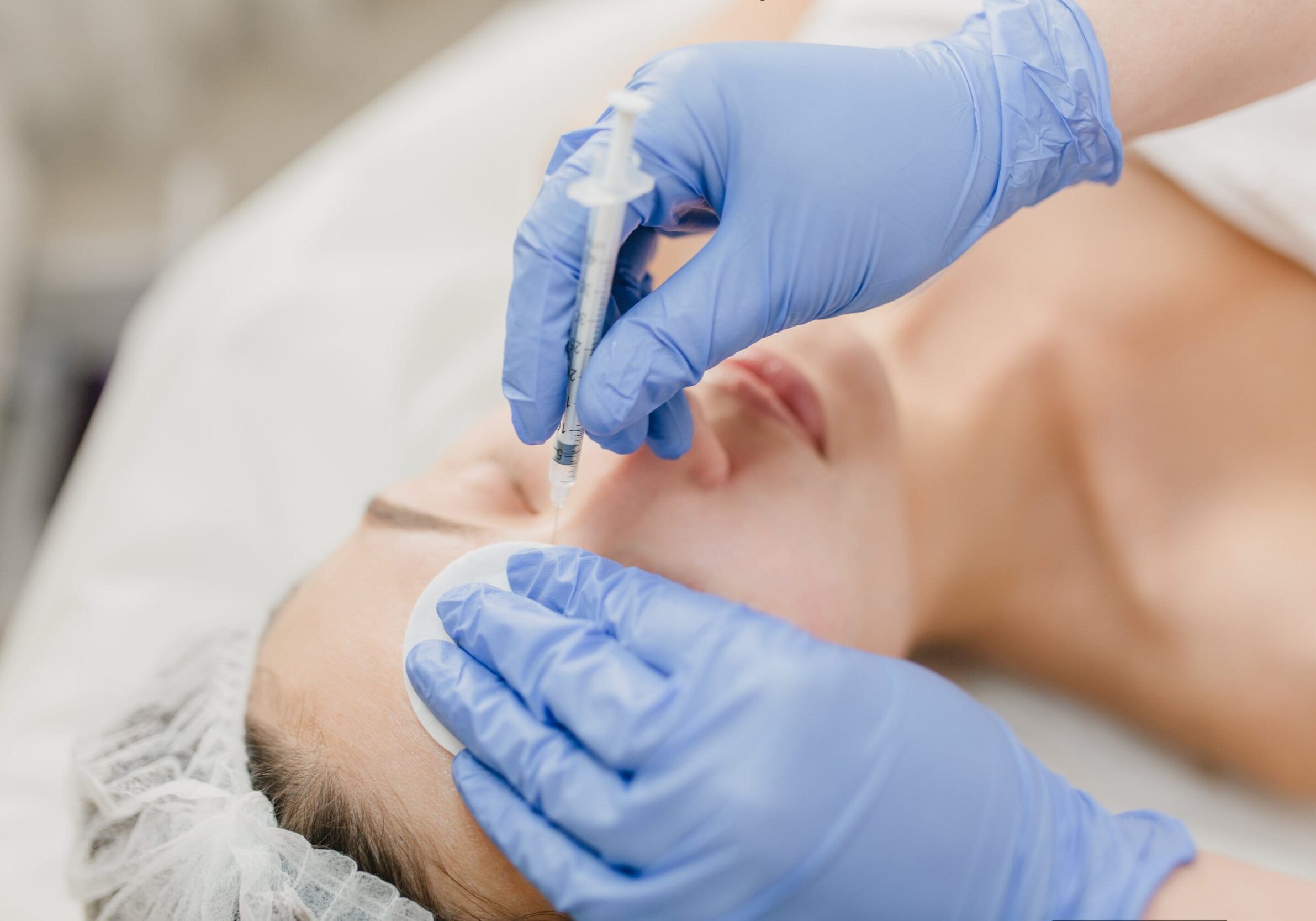 Hands in blue glows of cosmetologist at work with pretty woman during injection on face. Rejuvenation, professional, healthcare, medicine, medical therapy, skincare, botox. botox treatment lasalle forehead